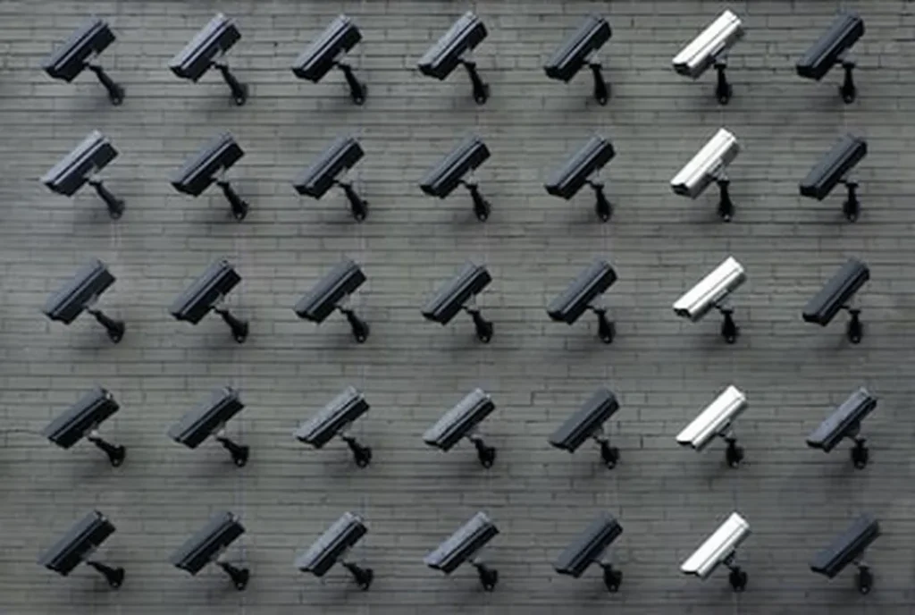 grid of security cameras on dark brick wall