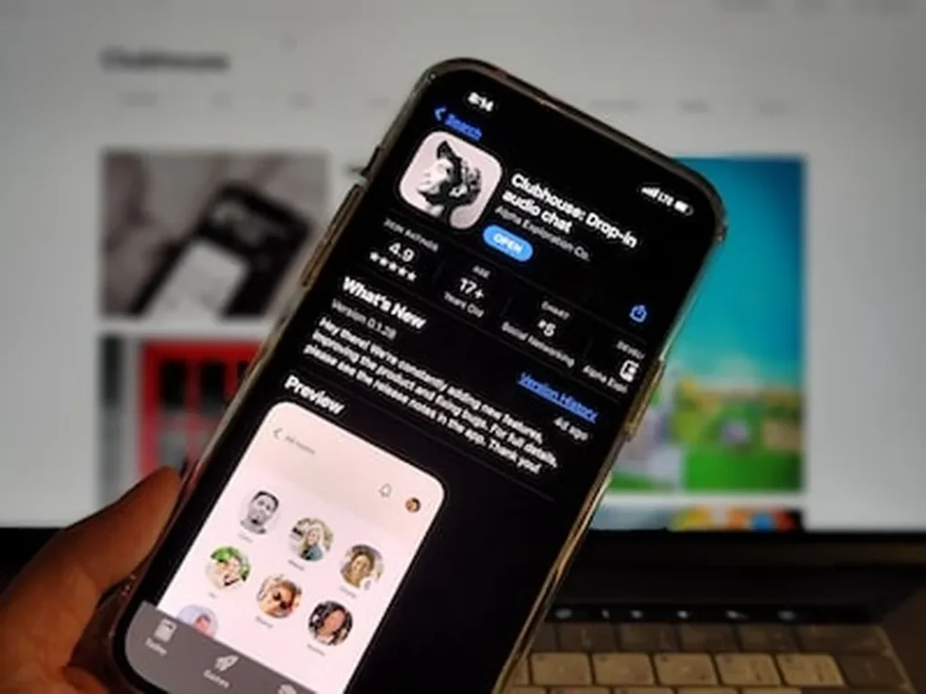 hand holding phone with app store screen showing clubhouse app